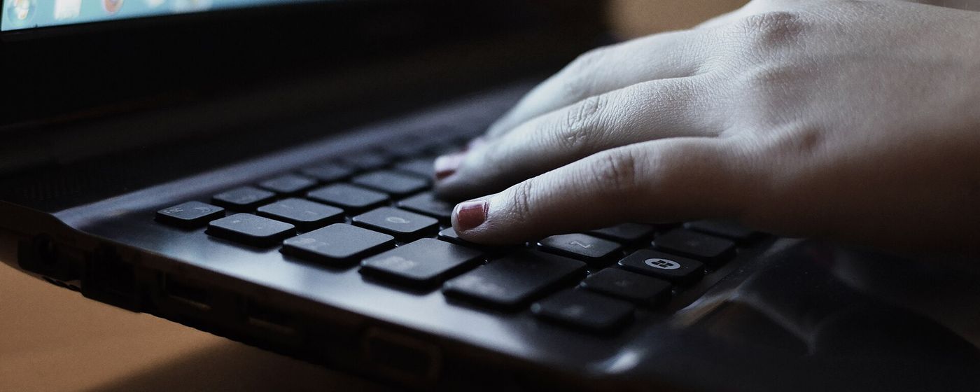 Hands typing on a laptop keyboard